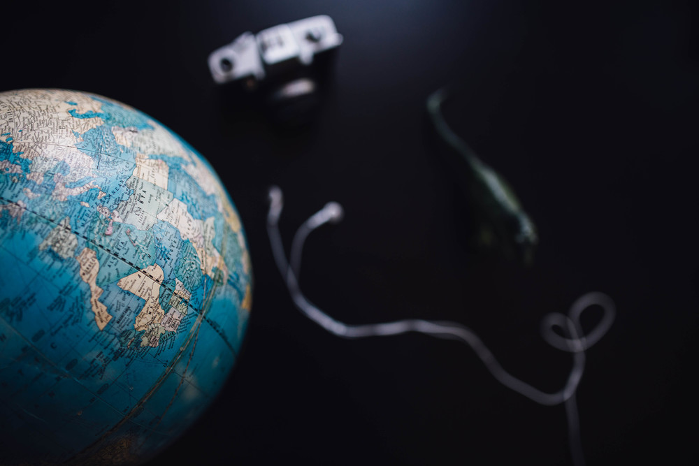 Vintage globe and camera sitting on black table.